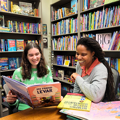 two women in library looking at book