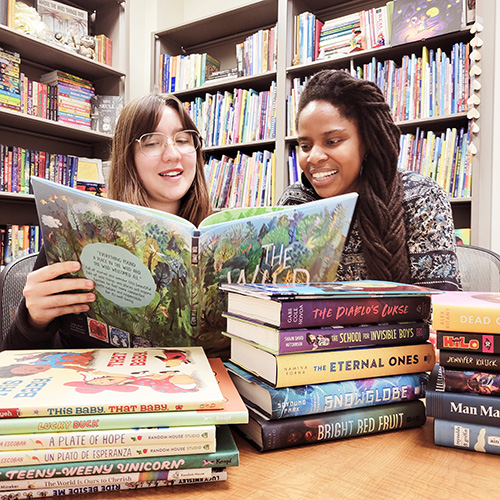 two women in library looking at book