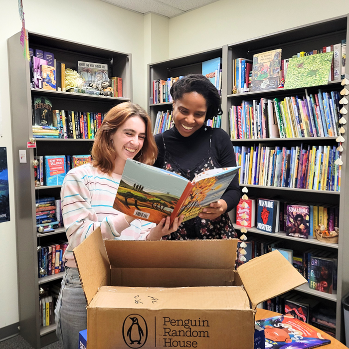 two women in library looking at book
